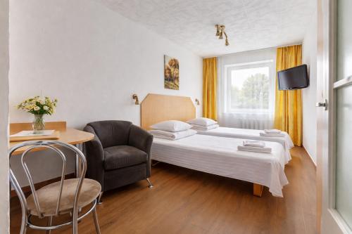 a hotel room with a bed and a chair at Velga in Vilnius