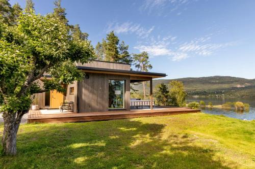 a house on the shore of a lake at Modern Cabin With Panoramic Views in Hønefoss