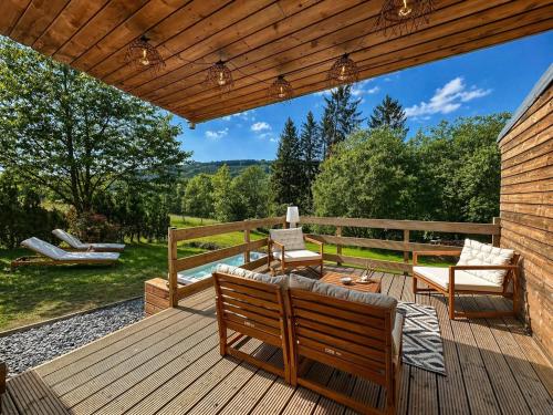 eine Holzterrasse mit zwei Stühlen und einem Tisch in der Unterkunft Chaly in Stoumont