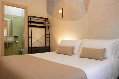 a bedroom with a white bed with two pillows at Vatican Dolce Remy Guest House - Metro Cipro in Rome