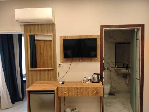 a room with a bathroom with a television on the wall at Up Town Crown Hotel in Cairo