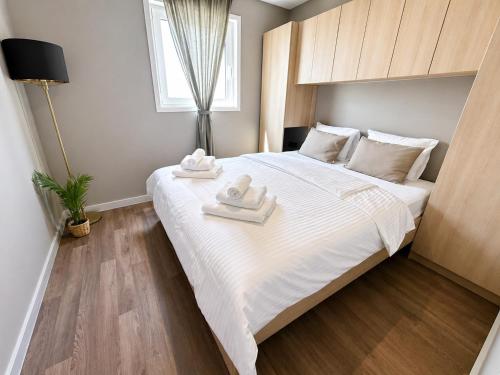 a bedroom with a large bed with two towels on it at Aurea Lux in Pakoštane