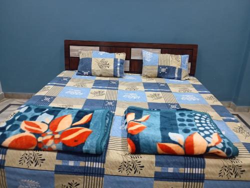 a blue bedroom with a bed with a blanket and pillows at DEV PALACE Hotel & Hostel in Palāi