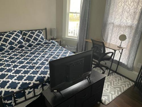 a bedroom with a bed and a flat screen tv at Homestay in Boston Fields Corner Area in Boston