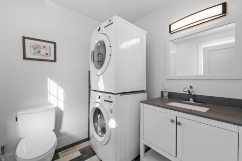 a white bathroom with a washing machine and a sink at Boston First floor condo in Framingham
