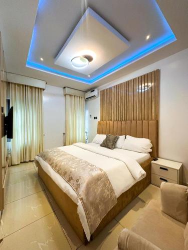 a bedroom with a large bed with a blue light at Supreme Apartments in Ibadan
