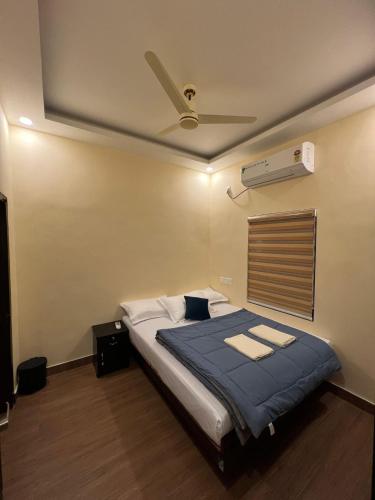 a bedroom with a bed with a ceiling fan at Oakeland By Grovien in Ponnāni