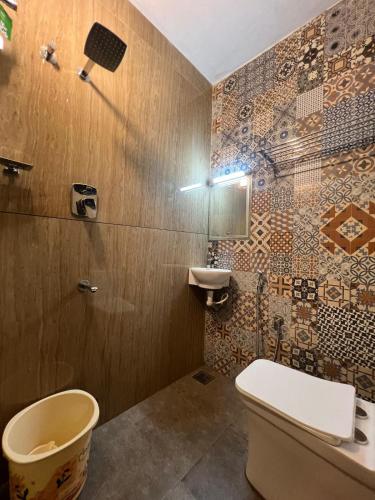 a bathroom with a toilet and a sink at Oakeland By Grovien in Ponnāni