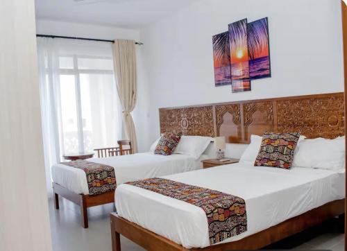 a hotel room with two beds and a window at WakaWaka SeaView Beach Condo in Mombasa