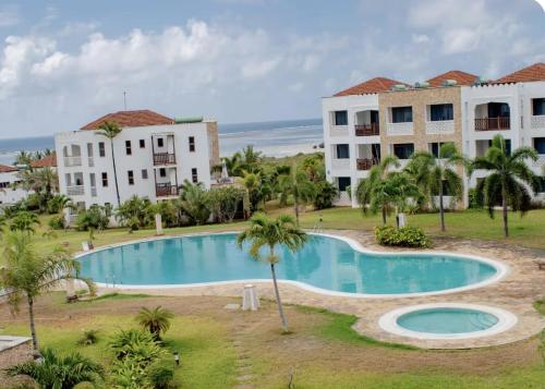 an image of a swimming pool in front of two buildings at WakaWaka SeaView Beach Condo in Mombasa