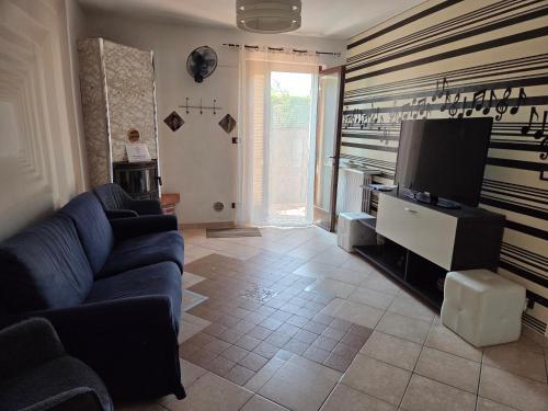 a living room with a blue couch and a flat screen tv at Casa PO LAZISE in Lazise