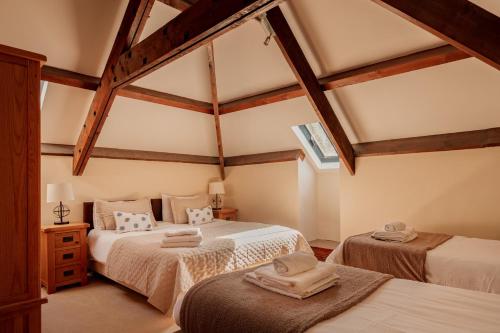 two beds in a room with wooden beams at Puffin Cottage, Bamburgh in Bamburgh