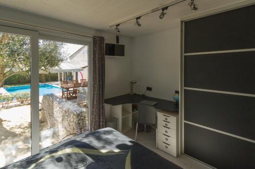 a bedroom with a bed and a sliding glass door at Les Pieds dans Thau in Marseillan