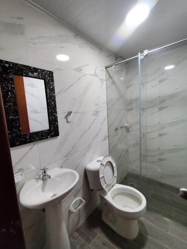 a bathroom with a toilet and a sink and a shower at Hotel La Terraza Raquireña in Ráquira