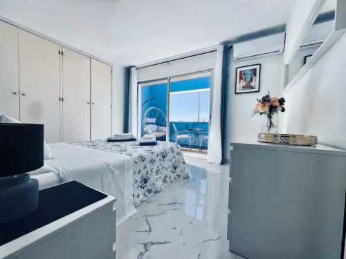 a white room with a bed and a large window at Casa Roxana in Porches