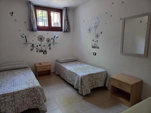 a bedroom with two beds and a mirror at Casa PO LAZISE in Lazise