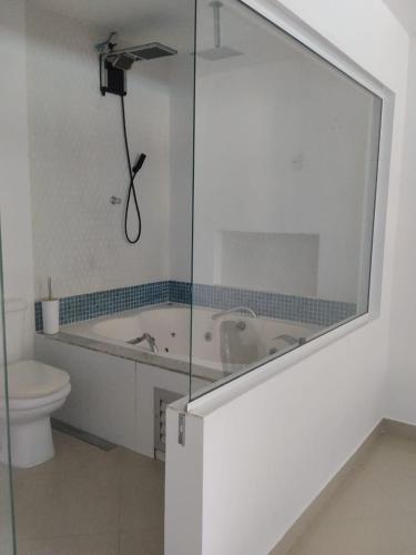a bathroom with a bath tub and a toilet at Apê Boa Vista in Vila Velha