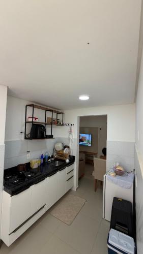 a kitchen with white cabinets and a stove top oven at Apt 102 in Parnamirim