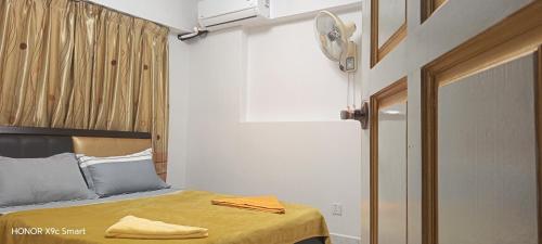 a bedroom with a bed with a yellow blanket on it at Hot Spring Residential B in Kuala Lumpur