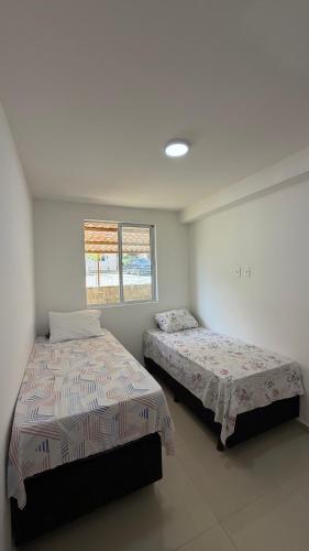 a bedroom with two beds and a window at Apt 102 in Parnamirim