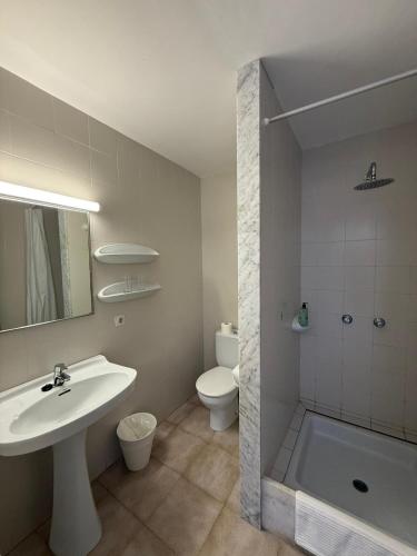a white bathroom with a sink and a toilet at Hostal Playa in Cala Santanyi