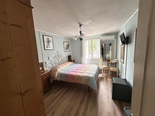 a bedroom with a bed and a table and a window at Casa Deanna in Querceta