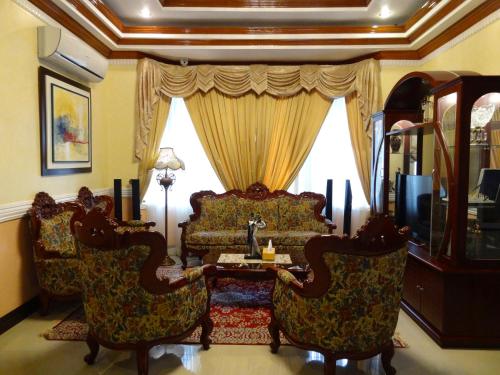 a living room with a couch and chairs and a table at The Executive Villa Inn & Suites in Davao City
