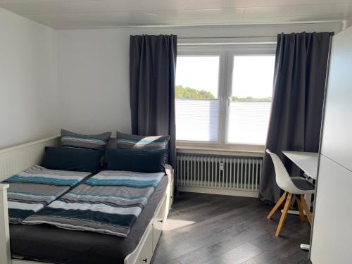 a bedroom with a bed and a desk and window at Ferienidylle im Westerwald in Seck