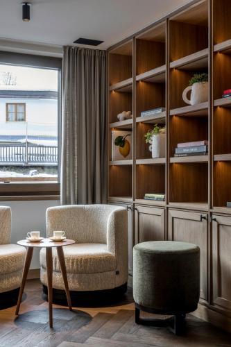 a living room with a chair and a table at Hotel Auenhof in Lech am Arlberg