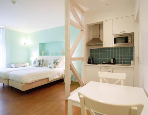 a small bedroom with a bed and a kitchen at Rossio Apartments in Lisbon
