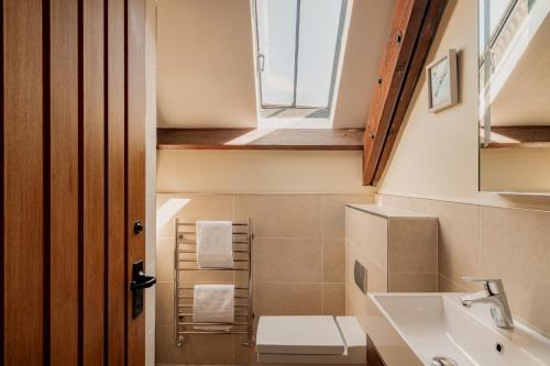 a bathroom with a sink and a toilet and a window at Puffin Cottage, Bamburgh in Bamburgh
