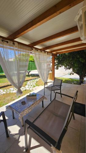 a patio with a table and chairs under a roof at Villa Dependance in Taranto