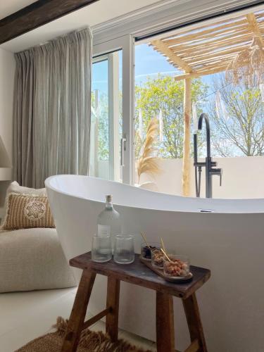 a bath tub in a bathroom with a window at Het sfeerhuis aan zee in Vlissingen