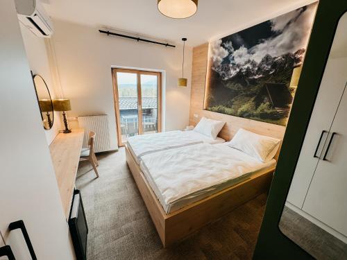 a bedroom with a bed and a painting on the wall at Hotel Oskar Zaplata in Preddvor