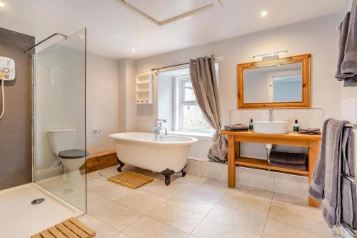 a bathroom with a tub and a sink and a mirror at 3 Bed in Kirriemuir oc-96450 in Kirriemuir
