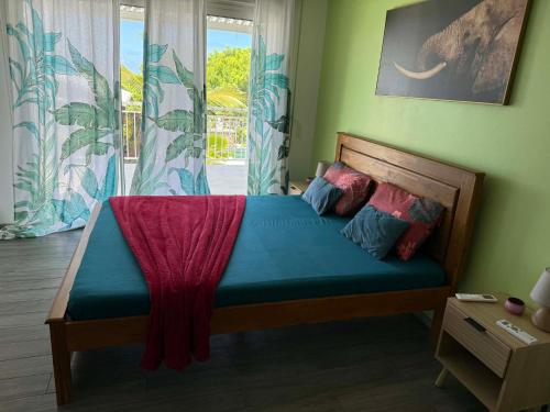 a bedroom with a bed in a room with a window at Villa oasis des laves in Sainte-Rose