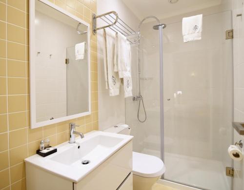 a bathroom with a sink and a shower and a toilet at Rossio Apartments in Lisbon