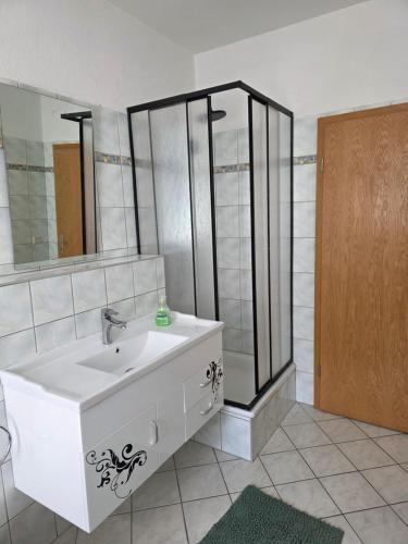 a bathroom with a white sink and a shower at FEWO Civrilli 1 Zeitz in Zeitz