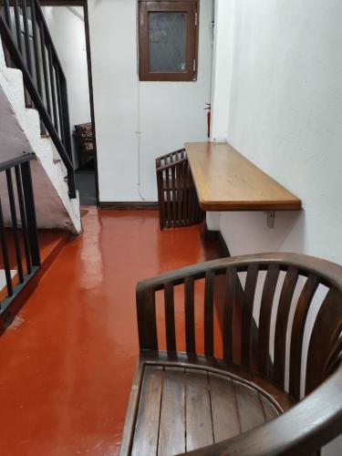 a wooden bench in a room with a table and stairs at Sri VK Residency - Buget Friendly Colombo Hotel in Colombo