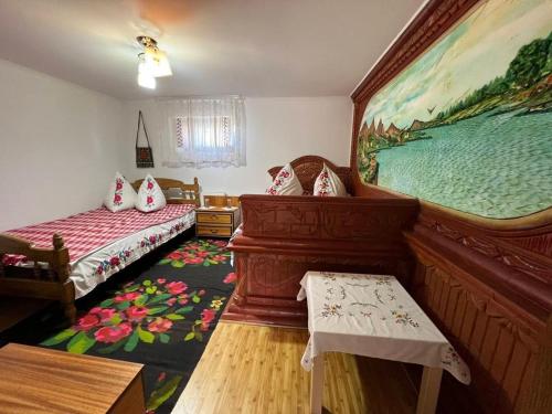 a room with two beds and a painting on the wall at Pensiunea Beciul Vechi in Mileştii Mici