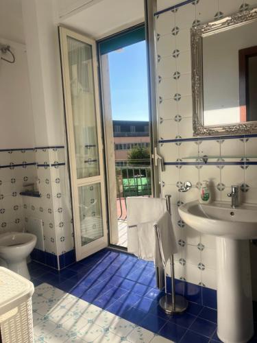 a blue and white bathroom with a sink and a mirror at Casa Castellano in Naples