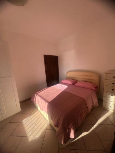 a bedroom with a bed with pink sheets and a dresser at Casa Castellano in Naples