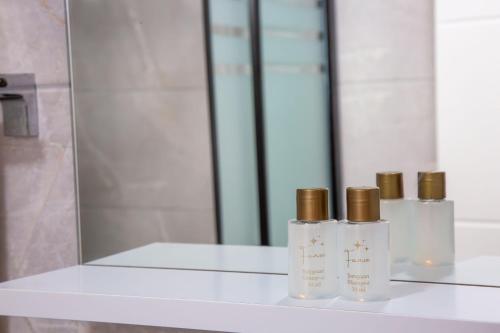 three perfume bottles sitting on a counter in front of a mirror at Ada Apart Hotel in Antalya