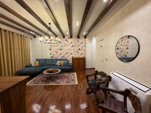 a living room with a blue couch and a table at Mikpritja Korçë in Korçë