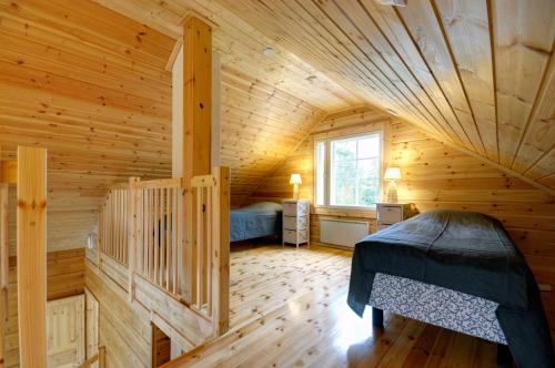 a log cabin with a bed in a room at Puttitie 4B in Tahkovuori