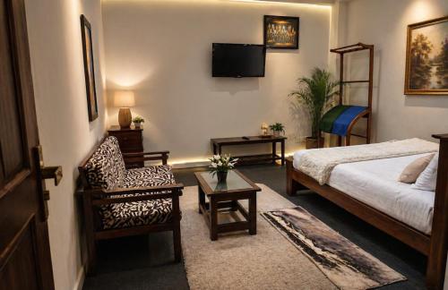 a bedroom with a bed and a chair and a tv at Sri VK Residency - Buget Friendly Colombo Hotel in Colombo