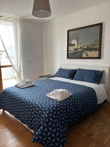a bedroom with a blue and white bed with two towels on it at MIALLEGRA Guest House in Bellona