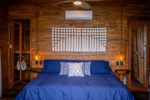 ein Schlafzimmer mit einem blauen Bett und einem Fenster in der Unterkunft Cabaña Jules in Bacalar