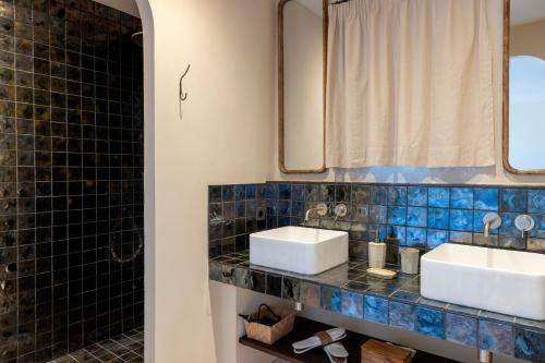 a bathroom with two sinks and a shower at Les Paillers de Bodri - Vue mer et piscine - Adults Only in Corbara