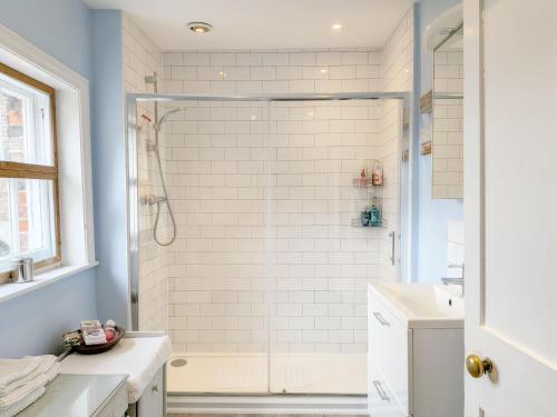 a bathroom with a shower with white tiles at Gainsford - Arundel in Arundel